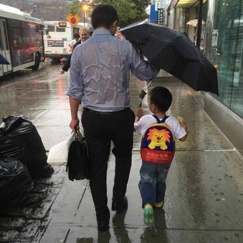 หนึ่งภาพแทนล้านคำ พ่อกางร่มไม่ให้ลูกเปียกฝน