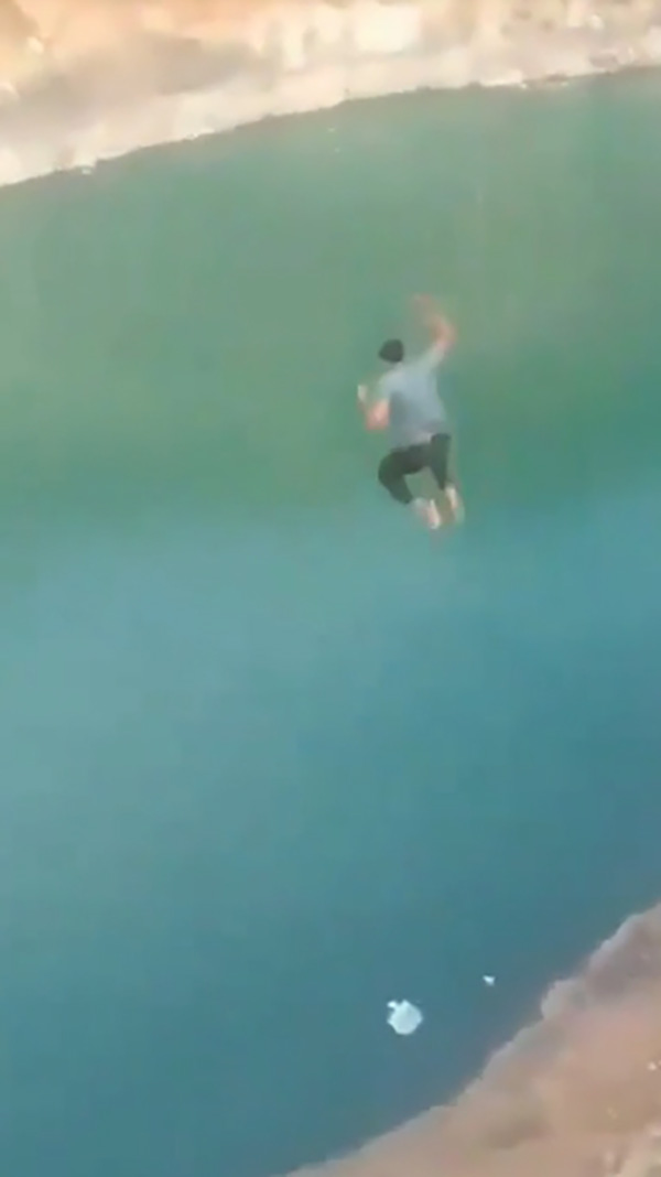 A young man, 18 years old, records a video of himself jumping into the lake